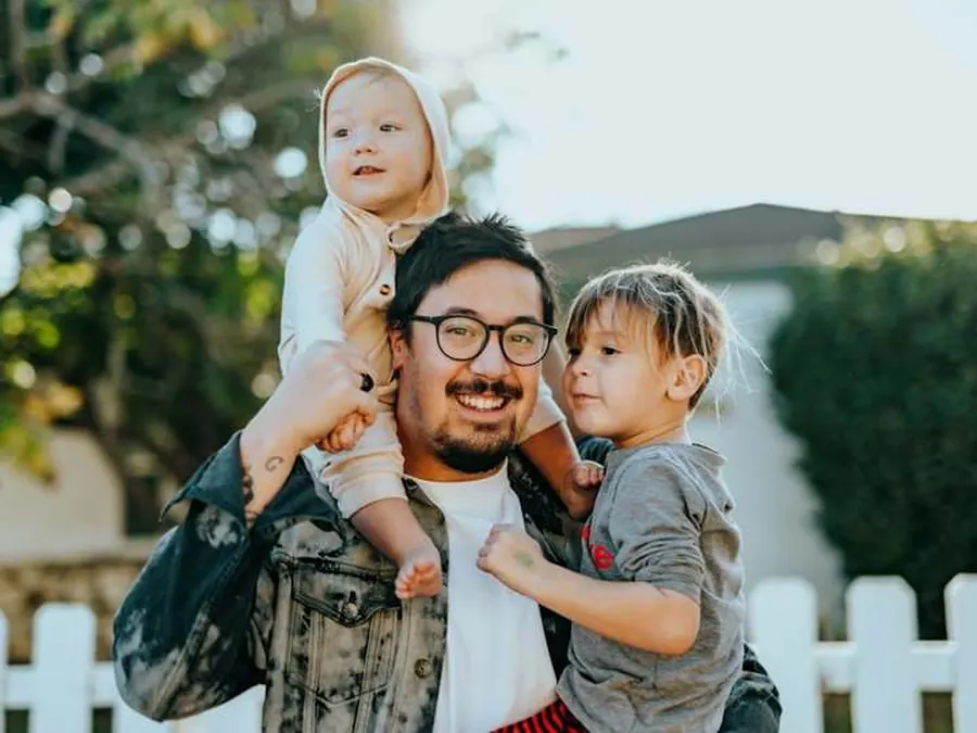 Pai com a filha no colo, motivo de contratar seguro de vida